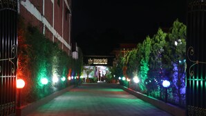 Vista nocturna de una entrada porticada a un edificio con un letrero que dice 'Imperial'.