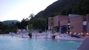 Un espace piscine avec des chaises longues et un bâtiment doté de grandes fenêtres.