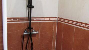 Una ducha con cabezal de ducha manual y sistema de ducha lluvia.
