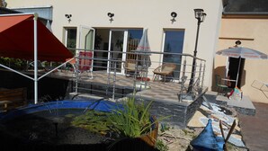 Un cortile con un piccolo stagno, mobili da esterno e un mulino a vento blu.