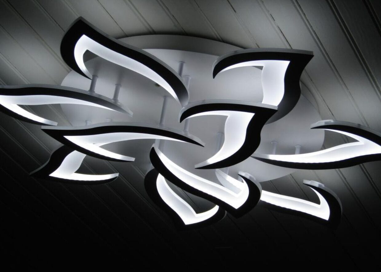 A modern, abstract light fixture with a metallic finish.