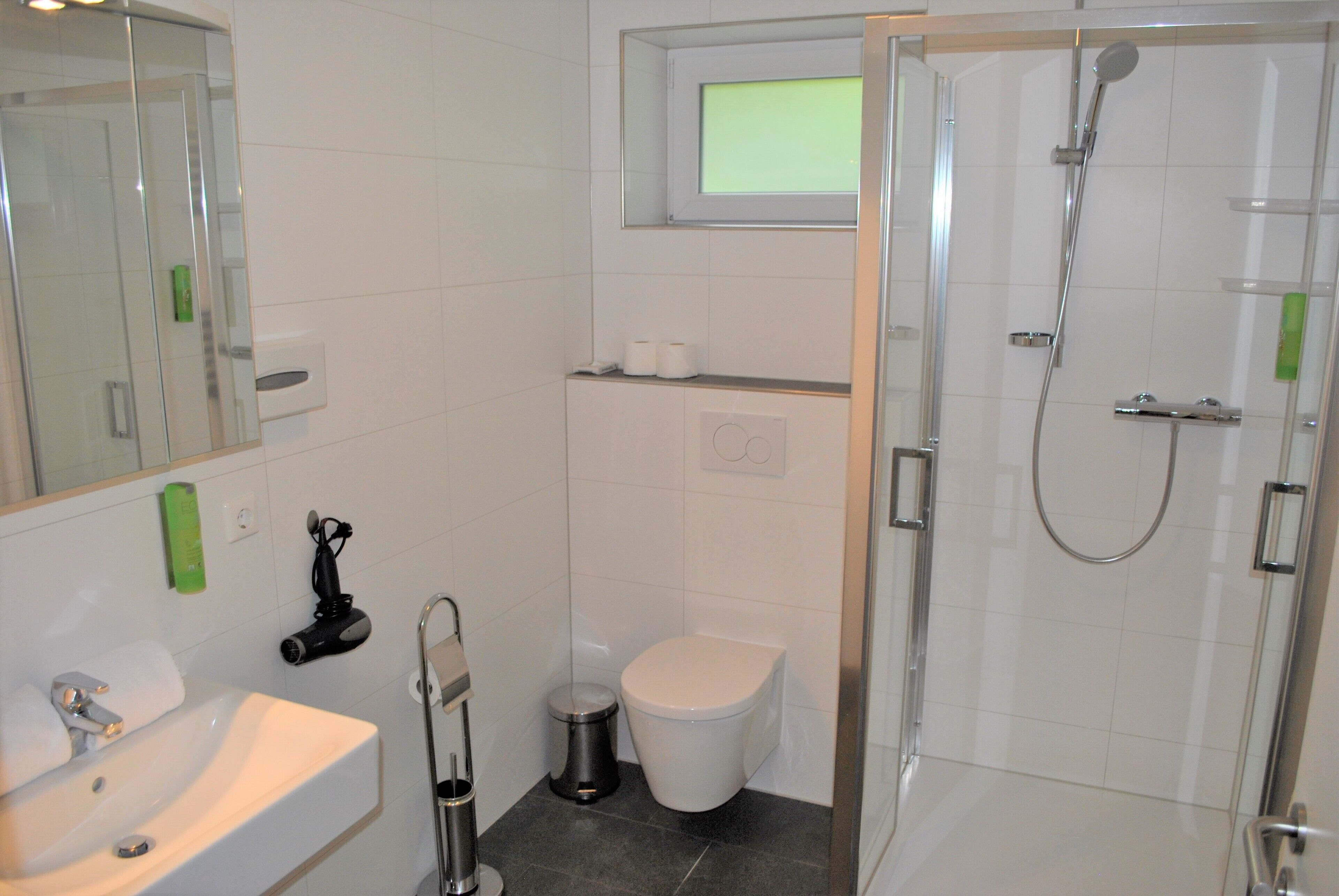 A bathroom with a sink, toilet, and shower.