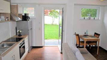 Una cucina moderna con forno integrato e zona pranzo con tavolo e sedie in legno.