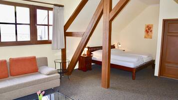 Un dormitorio con cama, sofá y una mesa de centro de vidrio.