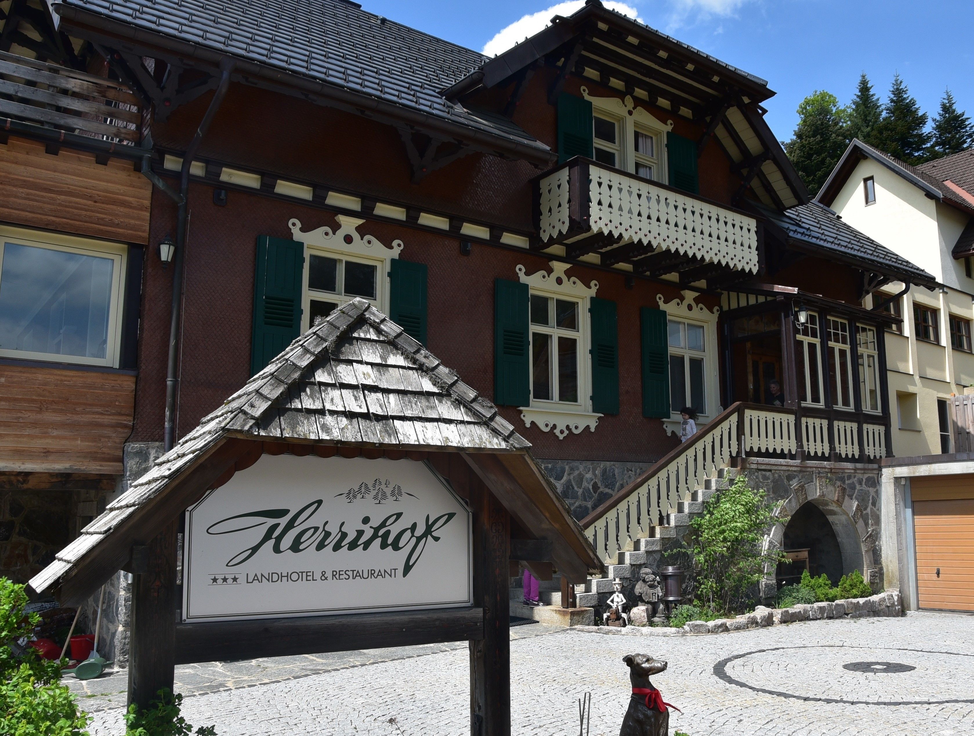 Un edificio de madera tradicional con un cartel que dice 'Flerrhof Landhotel & Restaurant'.