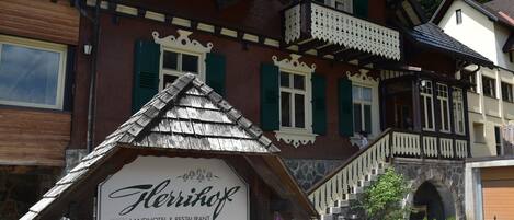 Un edificio de madera tradicional con un cartel que dice 'Flerrhof Landhotel & Restaurant'.
