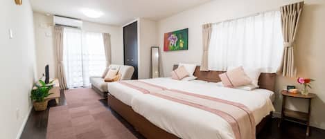 A modern bedroom with a large bed, a bedside table, a mirror, and a potted plant.