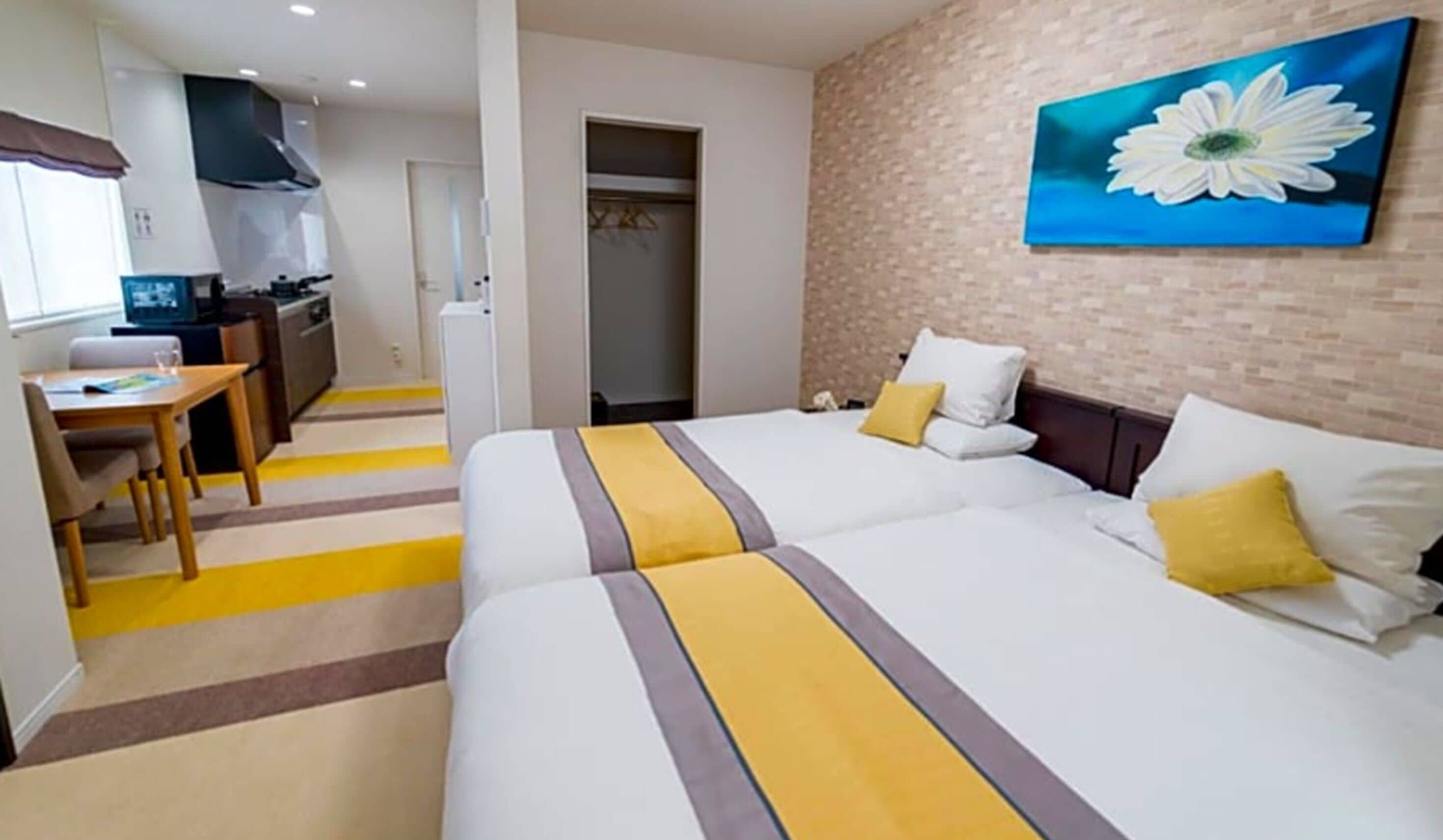 Una habitación de hotel con cama, escritorio y kitchenette.