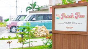 Señalización para 'Peach Fizz' con diseño tropical, indicando que es un hotel resort.
