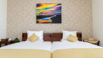 Una cama doble con ropa de cama blanca y dorada, un cabecero de madera y un cuadro colgado en la pared que muestra un atardecer sobre un río.