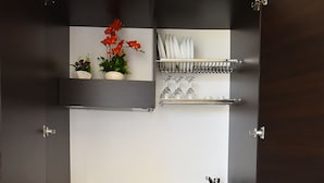 A compact kitchen with a built-in sink, a small refrigerator, and shelves for storage. - Borgo Fiorito Relais (Parabita)