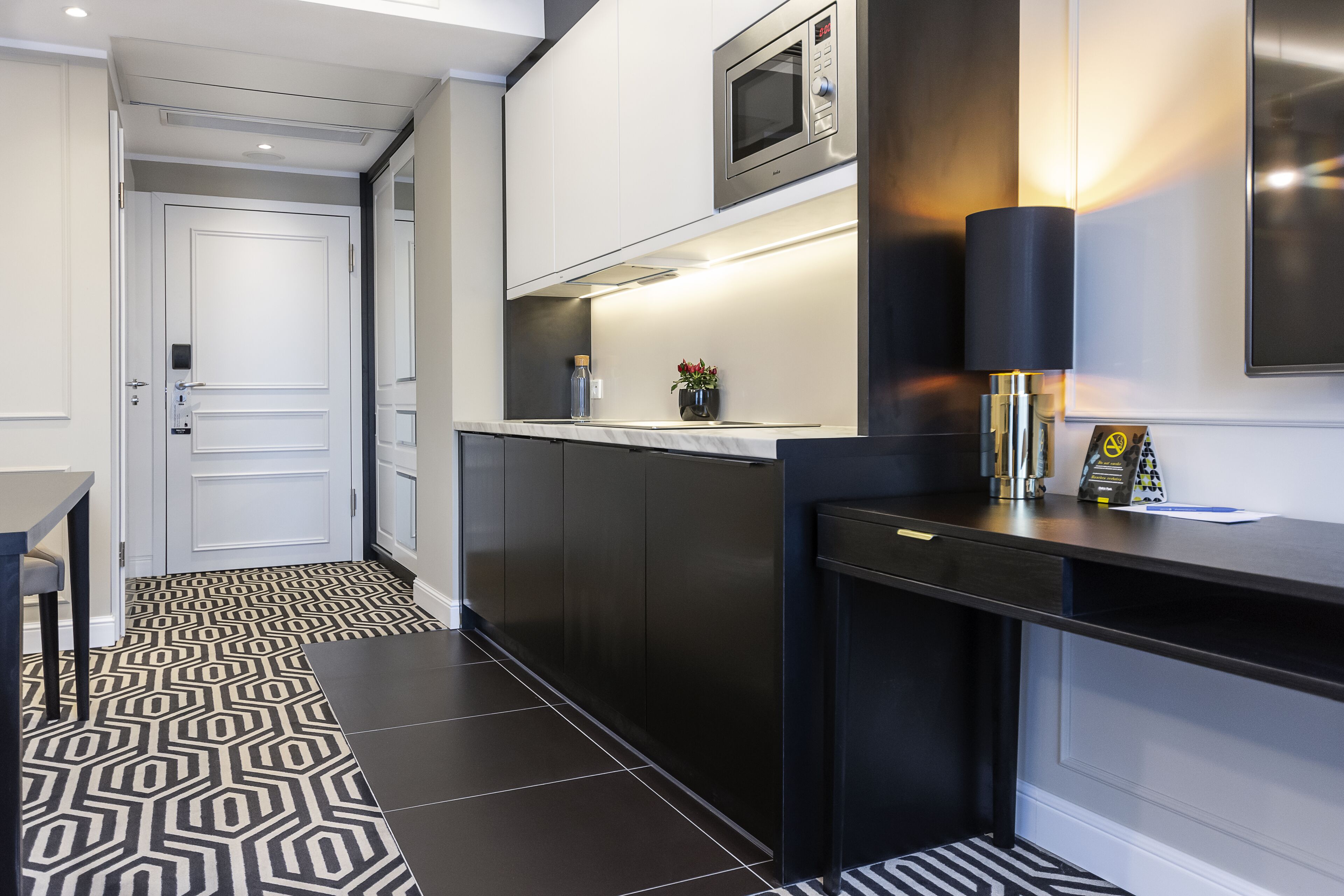 A modern kitchen with a microwave, a small table, and a cabinet.