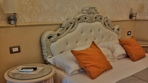 A bedroom with a tufted headboard, a round bedside table with a lamp, and a bed with two pillows. - Relais Toti B&B (Mogliano Veneto)