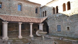 Un ancien bâtiment en pierre doté d’une cour, de colonnes et d’une fontaine.