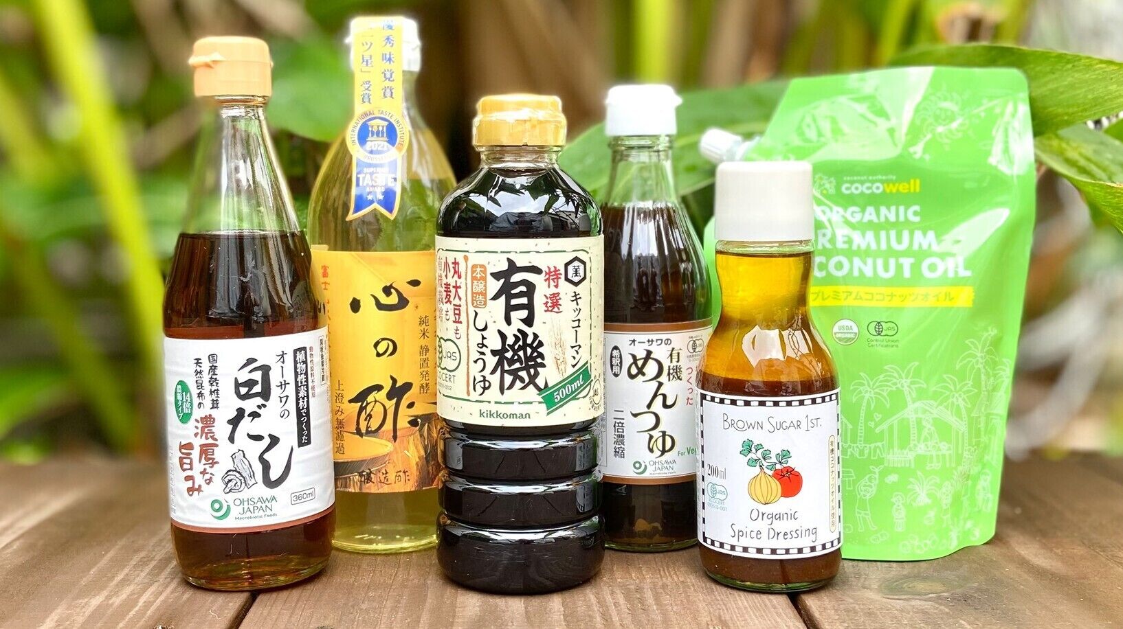 A variety of Japanese condiments and a coconut oil package on a wooden surface.