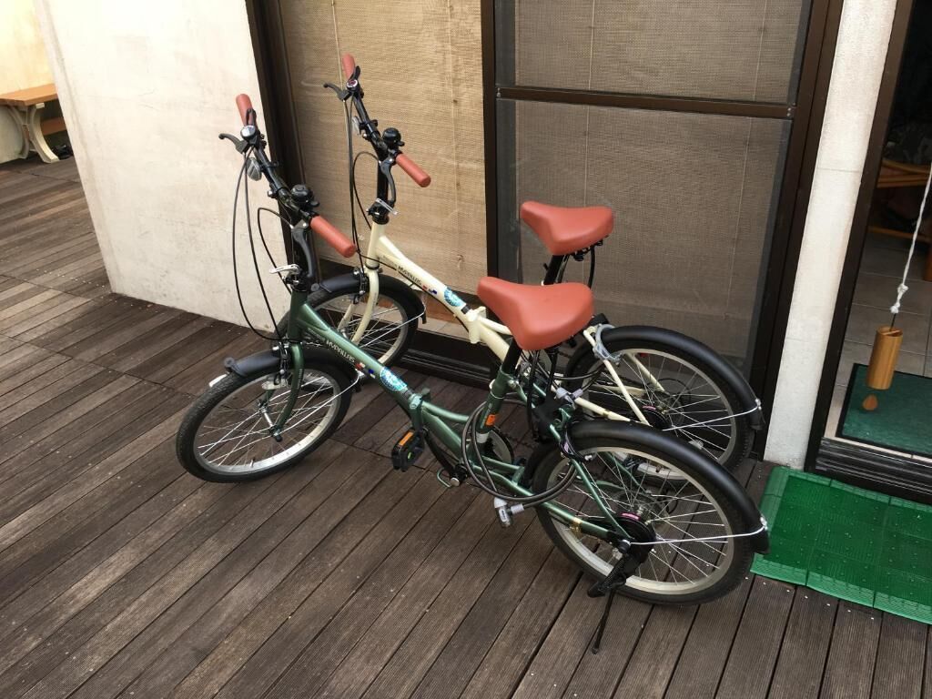 Ein Fahrrad steht auf einer Holzterrasse vor einem Gebäude.