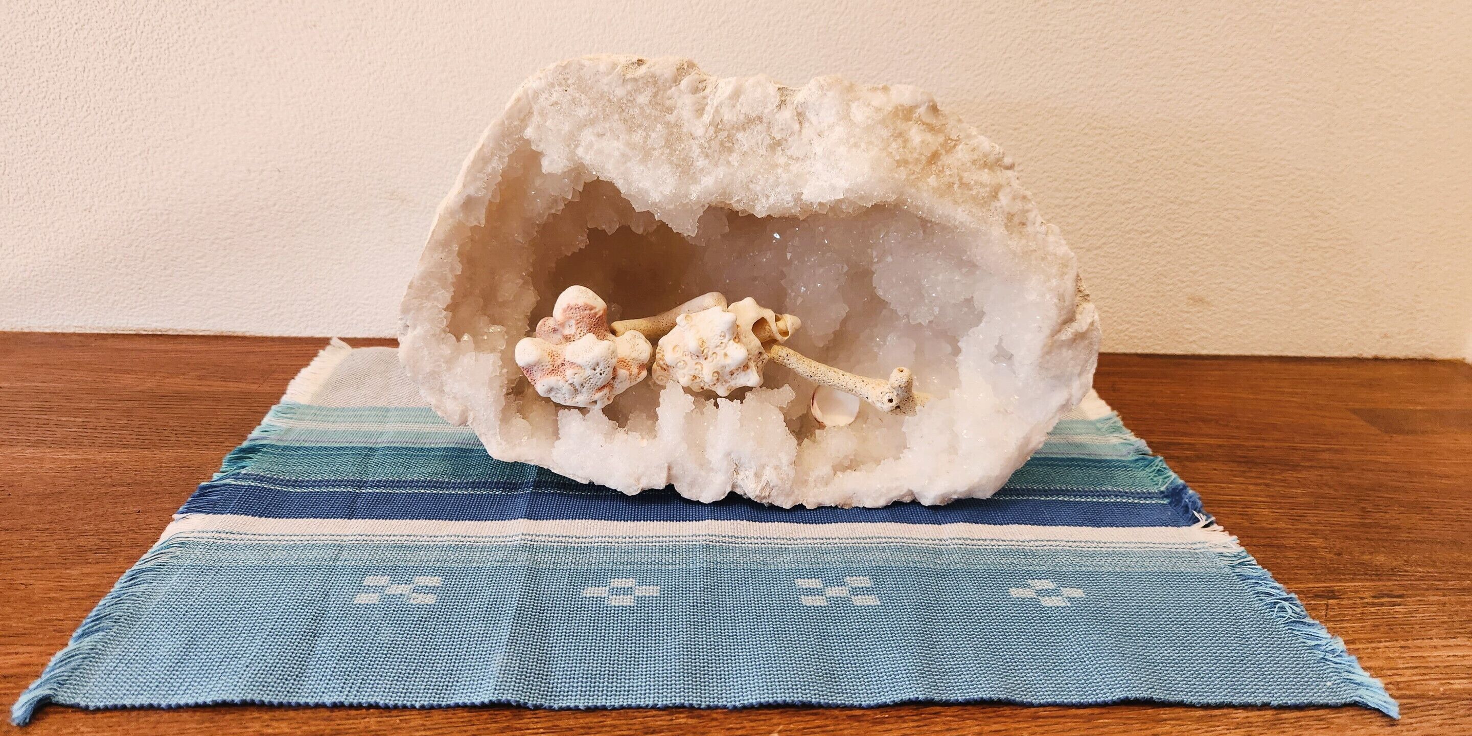 Una geoda grande sobre un tejido azul y blanco sobre una superficie de madera.