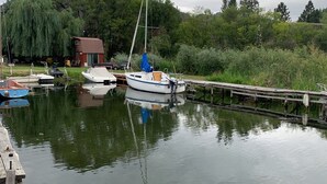 A calm water body with a dock and several boats moored.