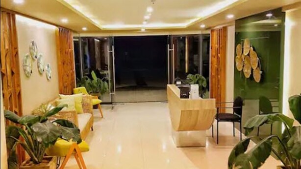 A modern hotel lobby with a reception desk, seating area, and potted plants. - Lolong's Listing - Mactan (Lapu-Lapu)