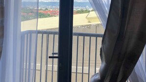 A room with a view of a cityscape through a window with sheer curtains. - Lolong's Listing - Mactan (Lapu-Lapu)
