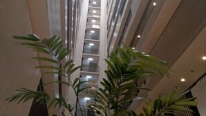 A high-rise building with multiple floors, a central staircase, and a series of balconies. - Lolong's Listing - Mactan (Lapu-Lapu)