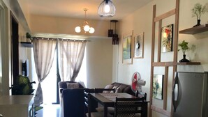 A modern kitchen with a dining area, a refrigerator, and a dining table with chairs. - Lolong's Listing - Mactan (Lapu-Lapu)