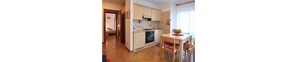 A compact kitchen with a stove, oven, and a dining table with chairs.