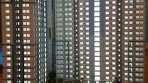 Un edificio de gran altura con varios pisos, que cuenta con un patio central con una fuente y abundante vegetación.