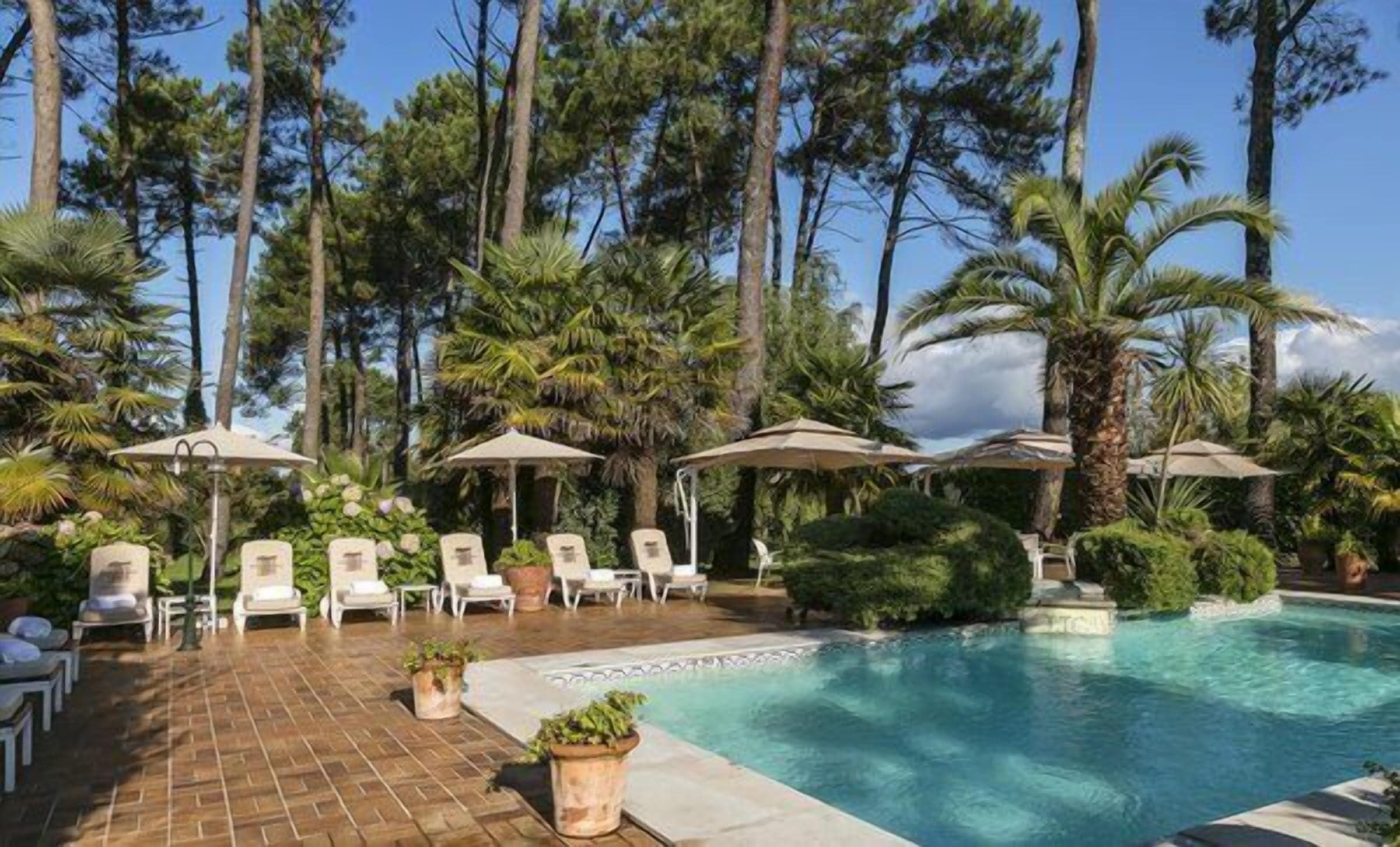 Una piscina cubierta, una piscina al aire libre, sombrillas, tumbonas
