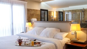A hotel room with a neatly made bed, a tray with breakfast items, a bedside lamp, and a shower area. - LE RELAIS DE LA POSTE (Magescq)