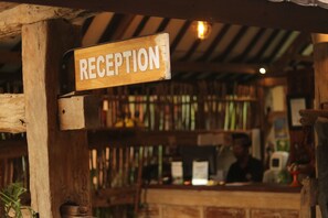 A wooden reception sign with the word "RECEPTION" mounted on a rustic wooden structure.