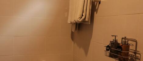 A bathroom with a toilet, a towel rack, and a hand dryer.