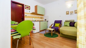 A compact living space with a dining area, kitchenette, and a sofa. - Apartments Aja and Stefy (Rovinj)