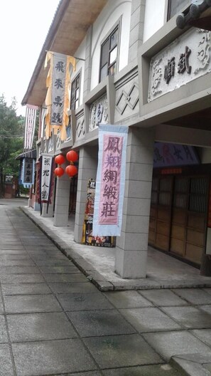 A row of traditional buildings with signage indicating various businesses, including a restaurant and a martial arts school. - Hale Crane Volcanic Mud Hot Spring Hotel (Tainan)
