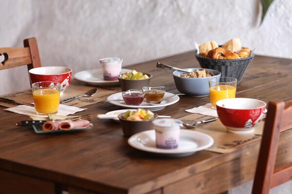 A breakfast table with various food items and drinks.