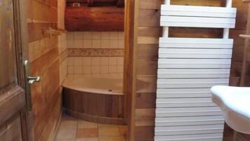 Un intérieur en bois avec un sol carrelé, un évier blanc et une porte en bois.
