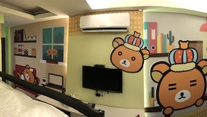A room with a bed, a TV mounted on the wall, and a mural with cartoon bears. - Fantastic Hostel (Taichung)