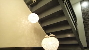 A staircase with a modern design, featuring a textured wall and a black railing. - Fantastic Hostel (Taichung)