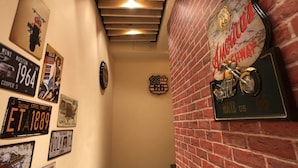 A hallway with vintage license plates and a motorcycle sign on the wall. - Fantastic Hostel (Taichung)