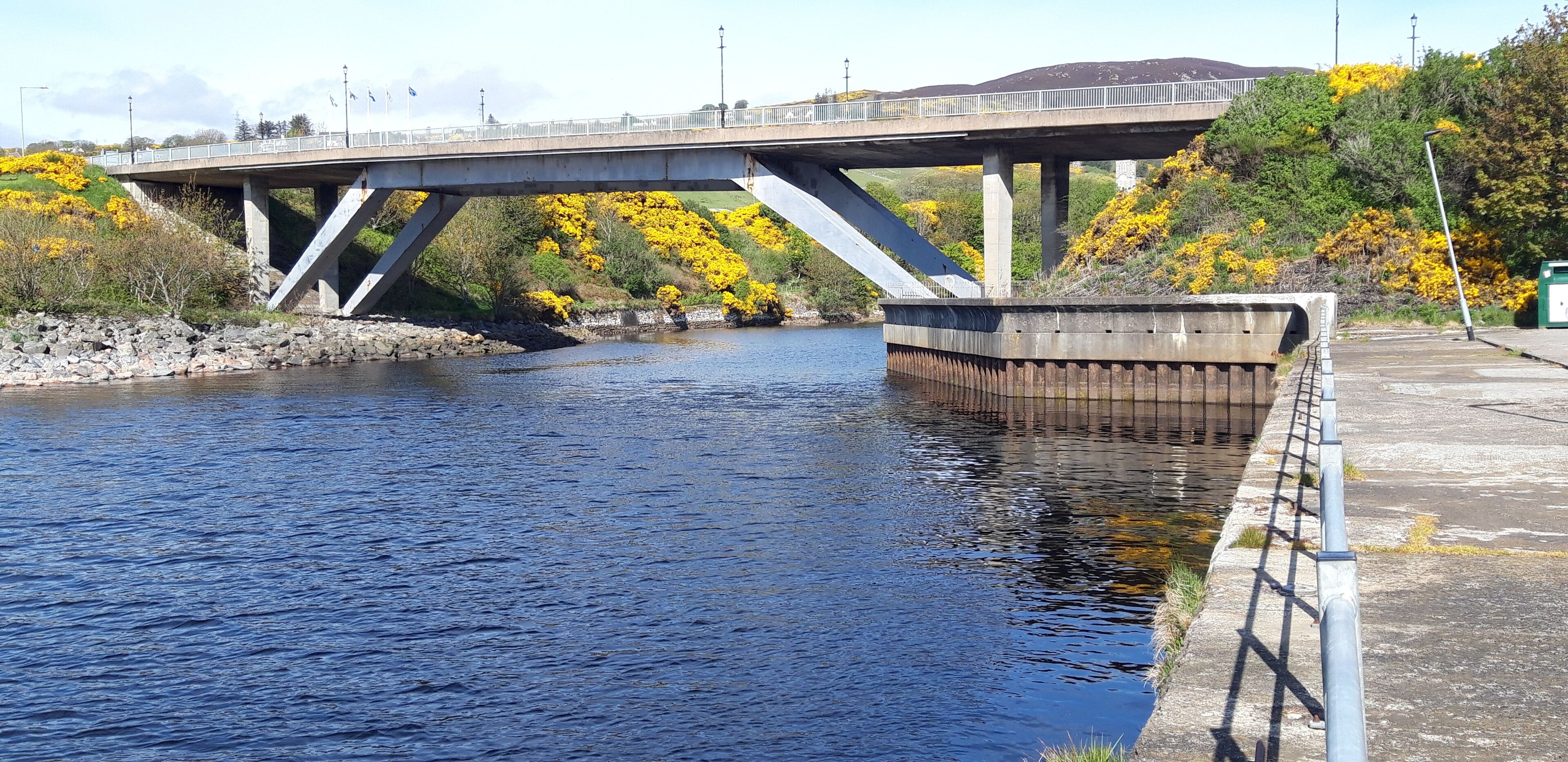 A bridge over a river with a concrete walkway on the right.