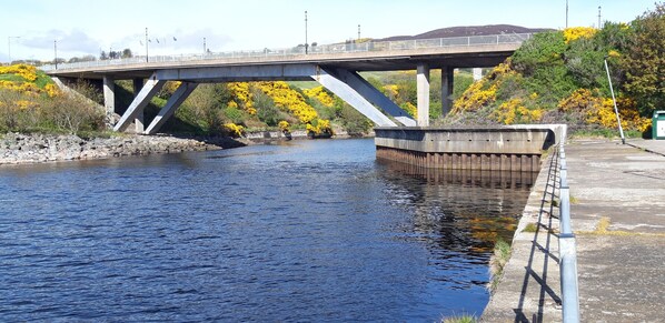A bridge over a river with a concrete walkway on the right.