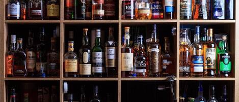 A wooden liquor cabinet with multiple shelves containing various bottles of alcohol.