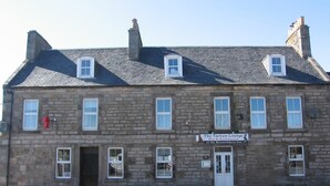 A stone building with a sign for 'The Tartan Lounge Bar & Restaurant at the Parnackburn Inn'.
