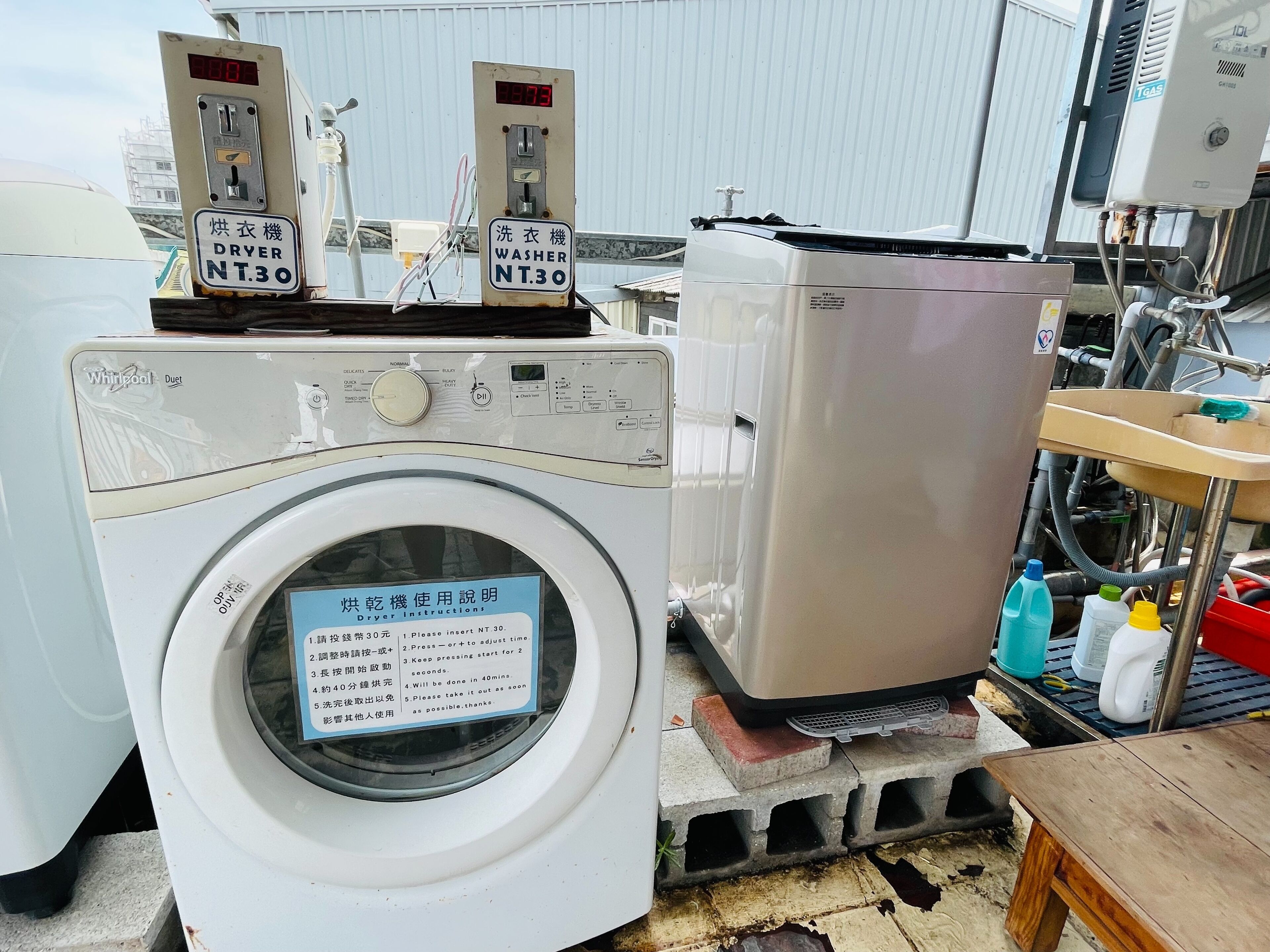 A front-loading washing machine with a control panel and a sign indicating it is a dryer and washer model NT.30.