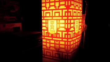 A traditional lantern with intricate patterns and Chinese characters, illuminated in a dark setting.