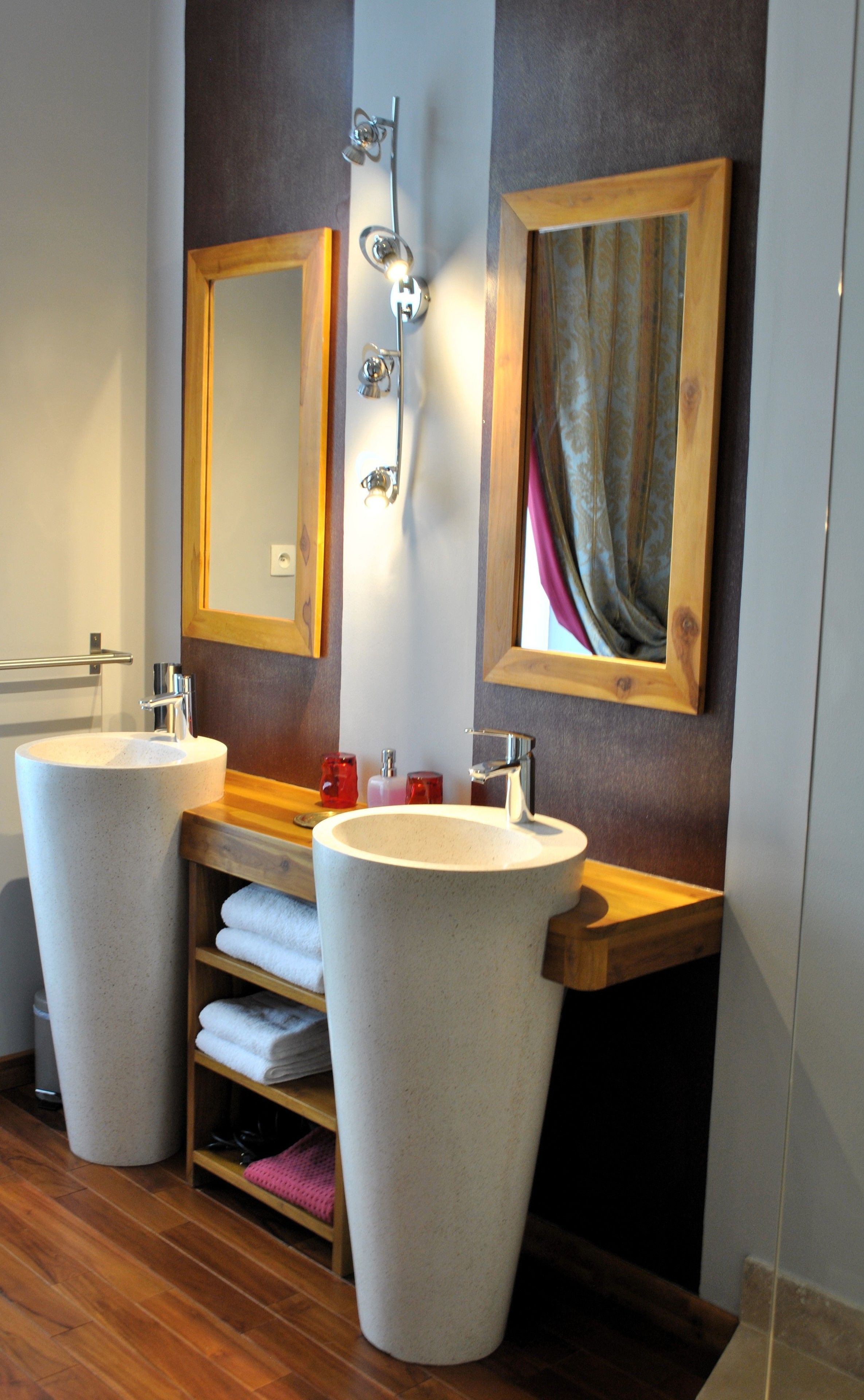 Une salle de bain avec deux grands lavabos, un miroir et un porte-serviettes.