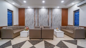 Un área de recepción con dos sofás, una mesa de centro y una alfombra estampada.