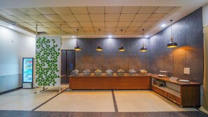 Una zona de recepción con un mostrador de madera, varias lámparas y un panel decorativo en la pared.