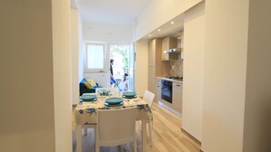 Una cocina moderna con armarios de madera y un comedor con una mesa dispuesta para dos.