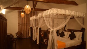 A traditional room with a four-poster bed, wooden furniture, and hanging lamps. - Micklefield Bungalow (Welimada)